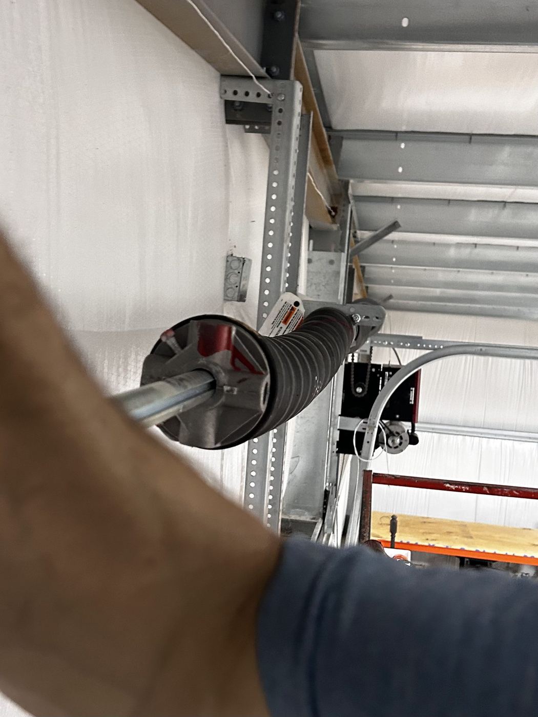Technician winding a commercial overhead door torsion spring